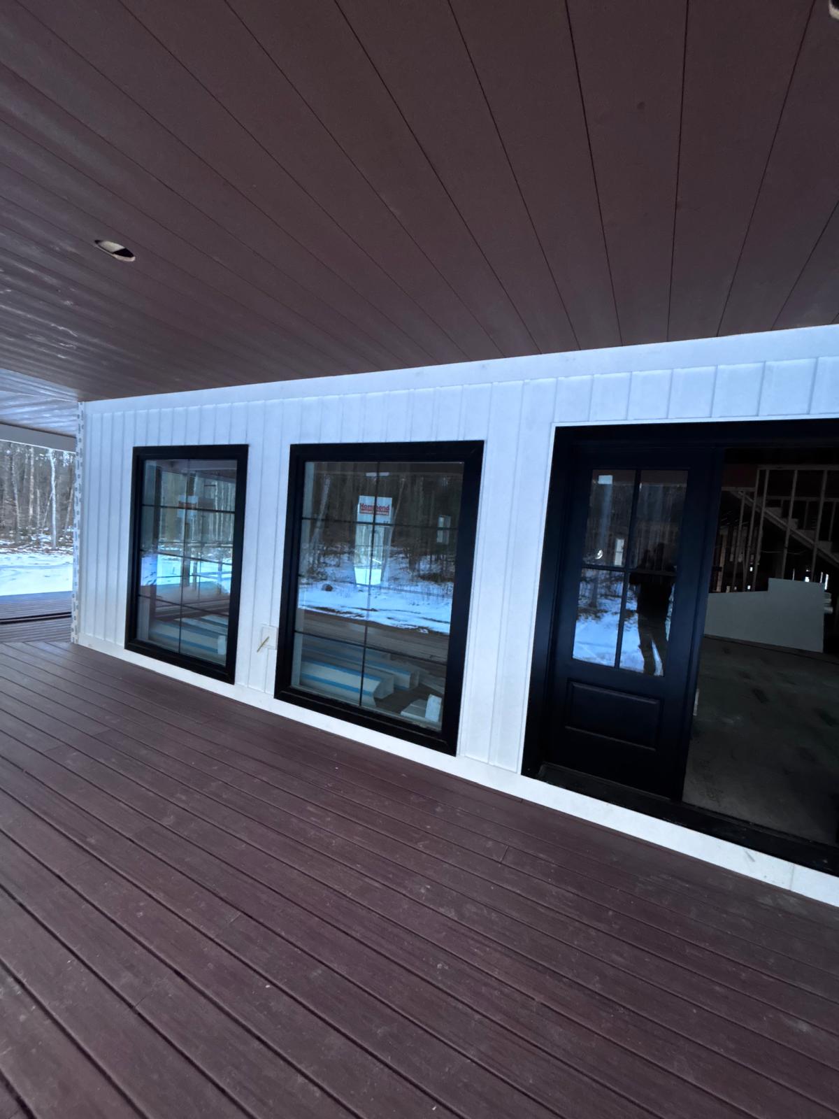 Finished porch with board and batten siding and black windows